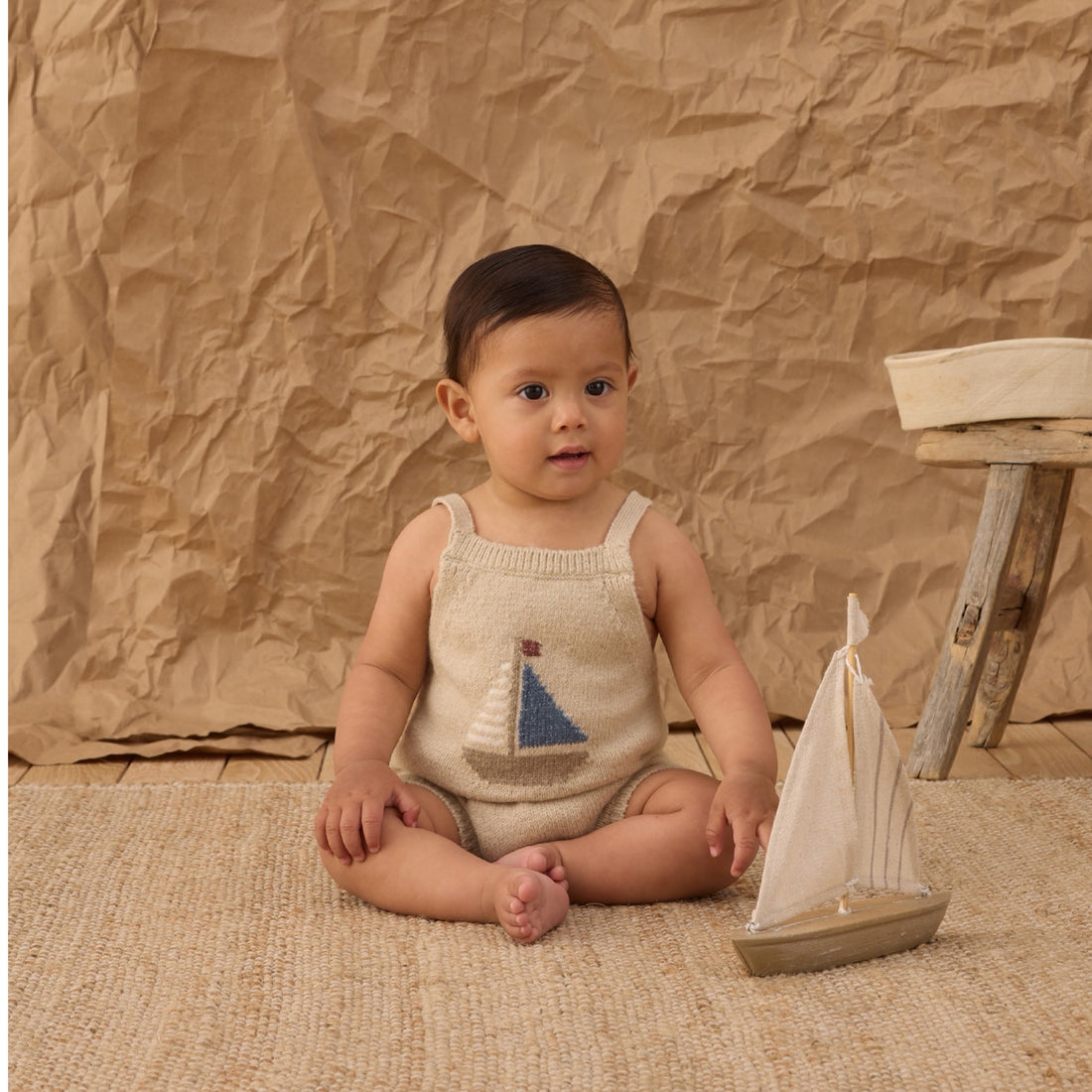 Beige knitted romper with sailboat design 