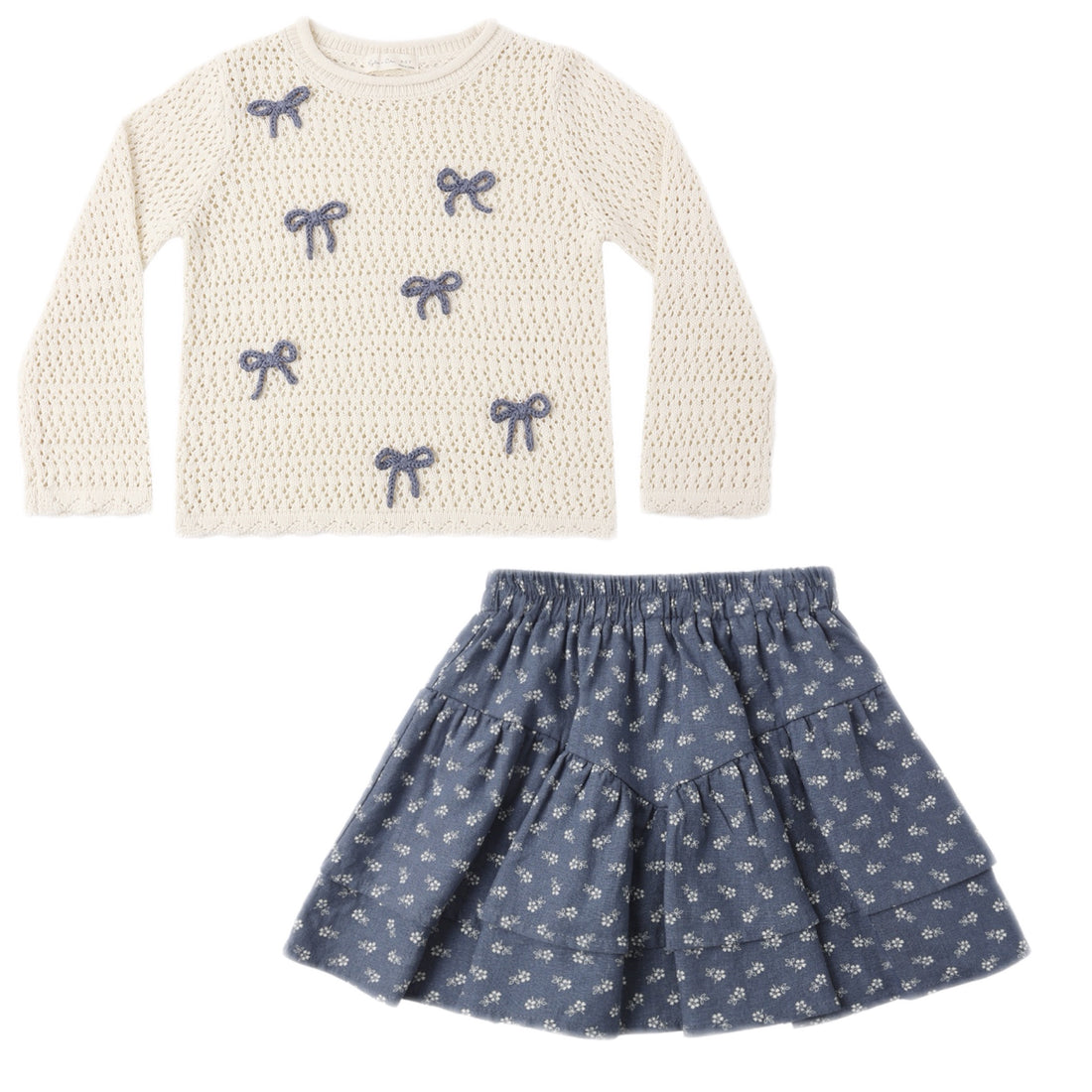 White sweater with blue bow patterns and a blue floral skirt