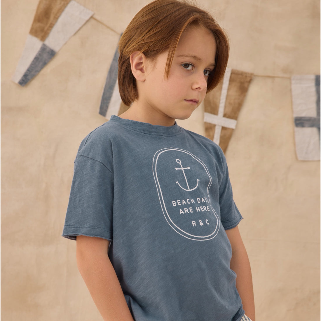Blue t-shirt with white anchor design and white text